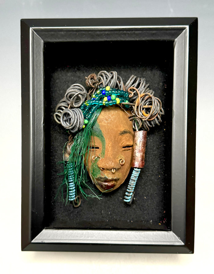At 5" x 8" in size, Marcel makes a stunning addition to walls, trees, and shadow boxes. His signature brown and amber braided hair is ornamented with handcrafted Raku beads, while his skin has a warm honey brown hue. Each piece is equipped with over 10 16 & 24-gauge wire in the hair. This fashionable sculpture will bring a modern flair to any room - simply place it in a shadow box and enjoy!
