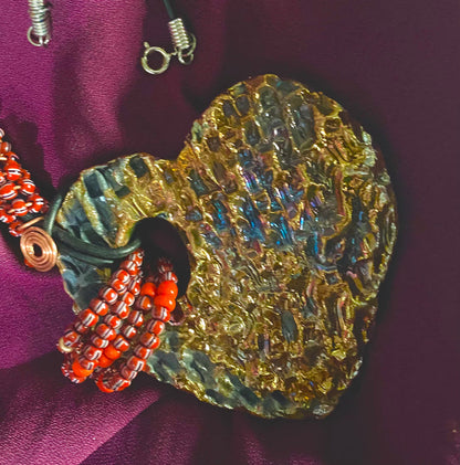 Have A Heart ! Each heart pendant is handmade with love! It is 3"x 3" and weighs approx. 3ozs. This pendant has a gold metallic raku glazes that renders a unique translucent  patina. The heart has a textured  pattern. It holds a spiral of ruby mini beads on a spiral copper wire. This pendant has a nice 12" black suede cord!