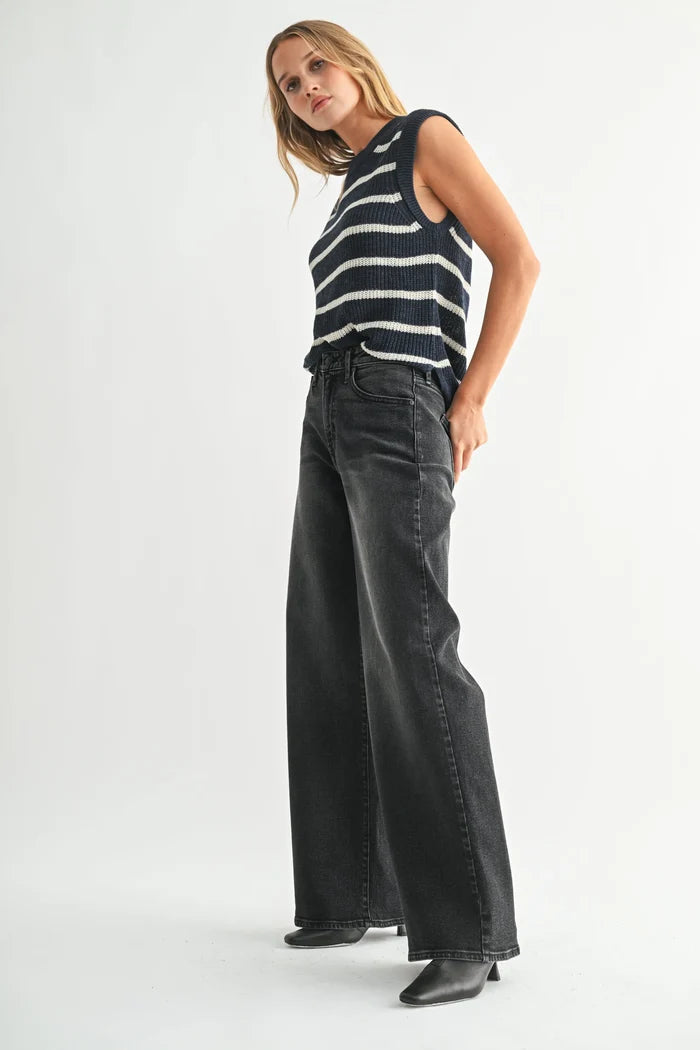Women’s black and white striped sleeveless sweater with high-rise wide-leg bohemian denim jeans