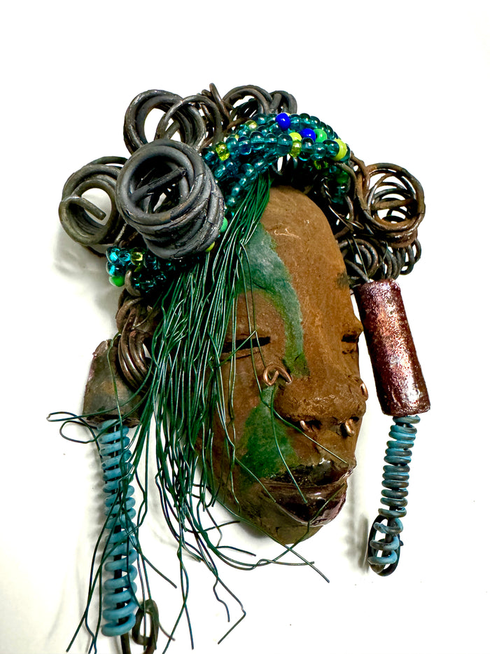 At 5" x 8" in size,  Marcel makes a stunning addition to walls, trees, and shadow boxes. His signature brown and amber braided hair is ornamented with handcrafted Raku beads, while his skin has a warm honey brown hue. Each piece is equipped with over 10 16 & 24-gauge wire in the hair. This fashionable sculpture will bring a modern flair to any room - simply place it in a shadow box and enjoy!