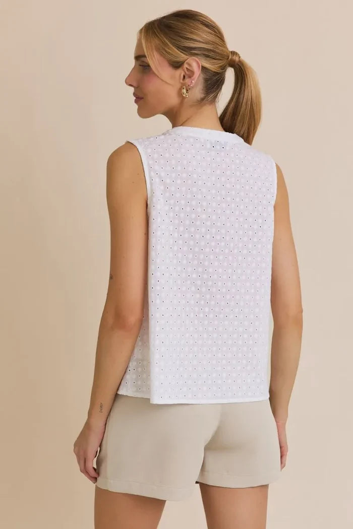 Woman in white eyelet tank top and beige shorts, showcasing women’s boho chic clothing from Shop Daisy
