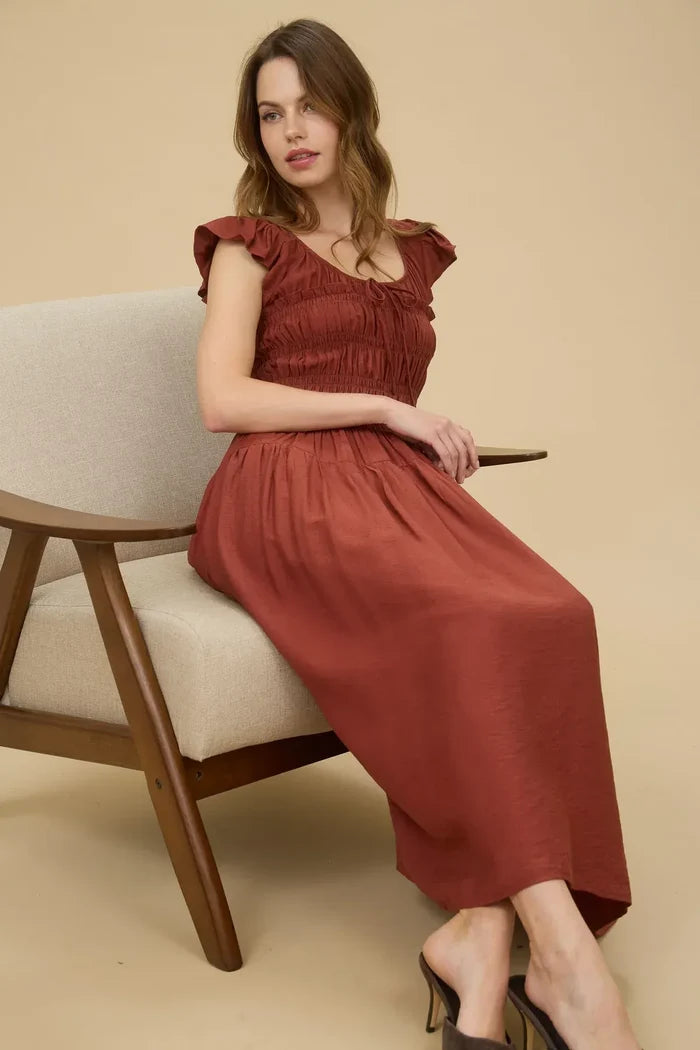 Rust-colored midi dress with shirred bodice and ruffled cap sleeves for elegant style